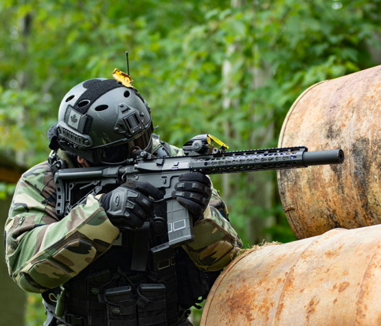 photo of paintball player in Ottawa hiding behind barrels