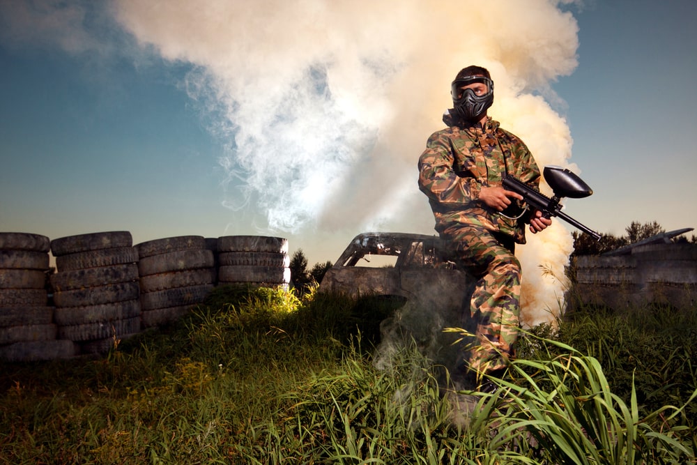 A man with paintball gear defending his hill.