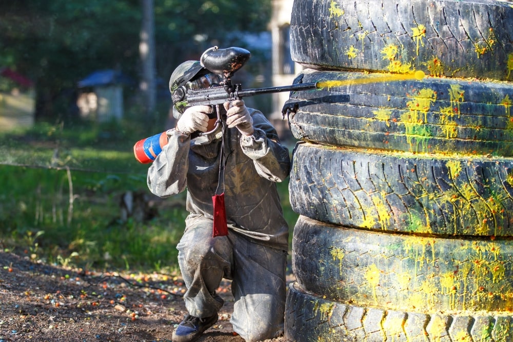 man shooting paintball gun